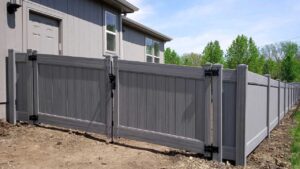 Gray vinyl privacy fence installed by Elite Fence in Raymore MO, showcasing modern design and durable craftsmanship that adds beauty and value to residential properties.