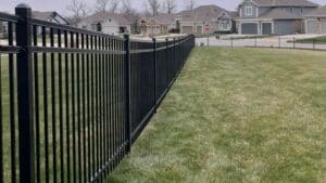 Aluminum ornamental fence installed in a residential neighborhood, illustrating aluminum vs steel fence comparison by Elite Fence in Raymore MO.
