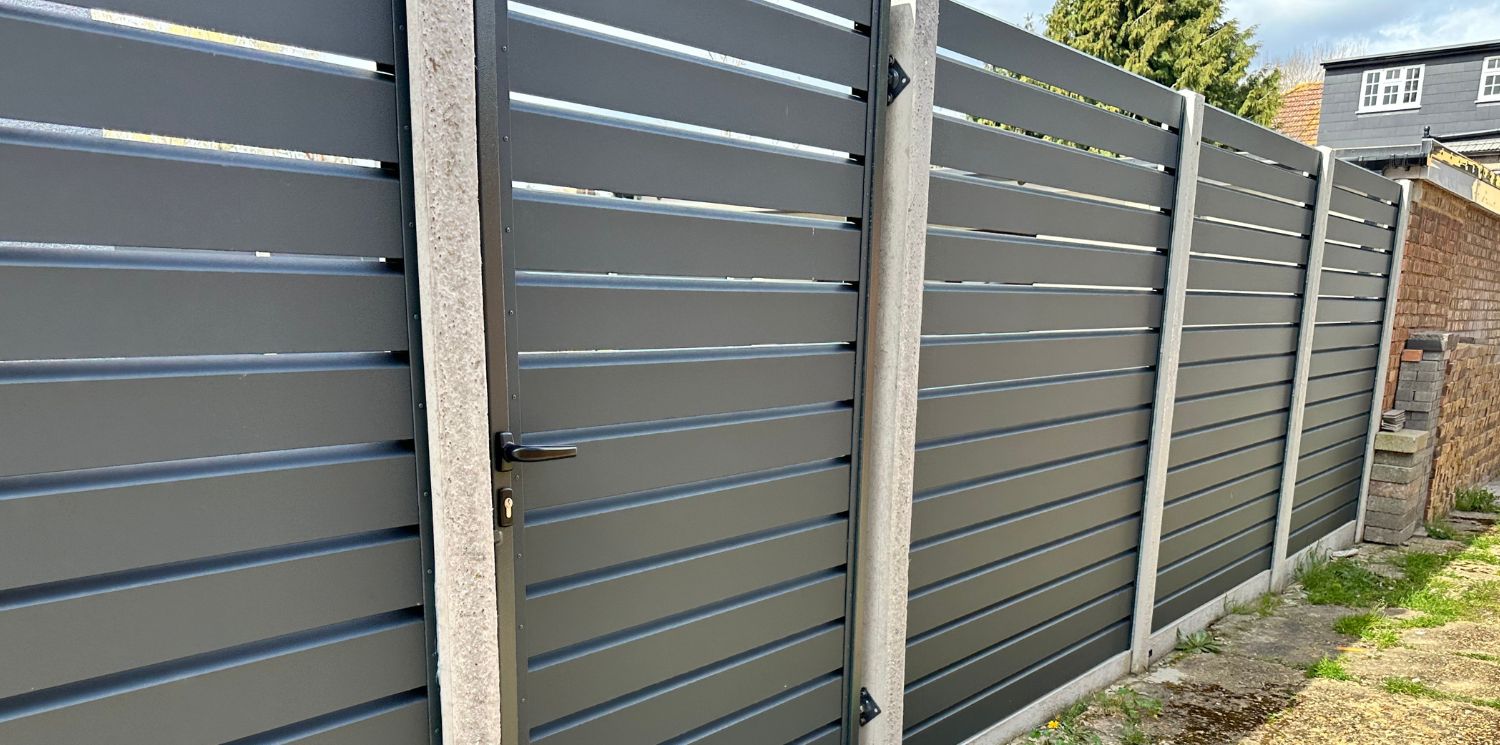 Elite Fence installation of a Centurion Select Aluminum dark horizontal slat fence with integrated gate and concrete posts.