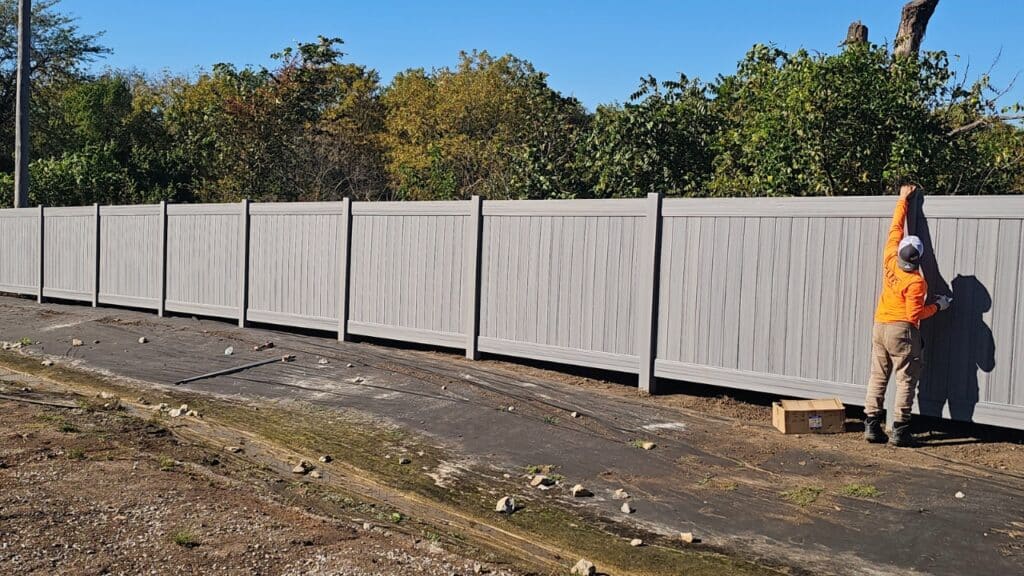 Professional installation of a gray vinyl fence to maximize vinyl lifespan and ensure structural integrity for years.