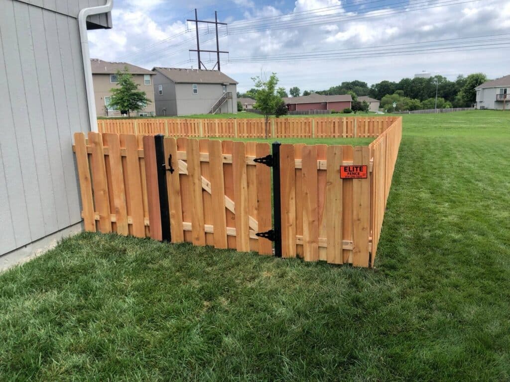 Cedar shadowbox fence with a black steel gate post installed by Elite Fence