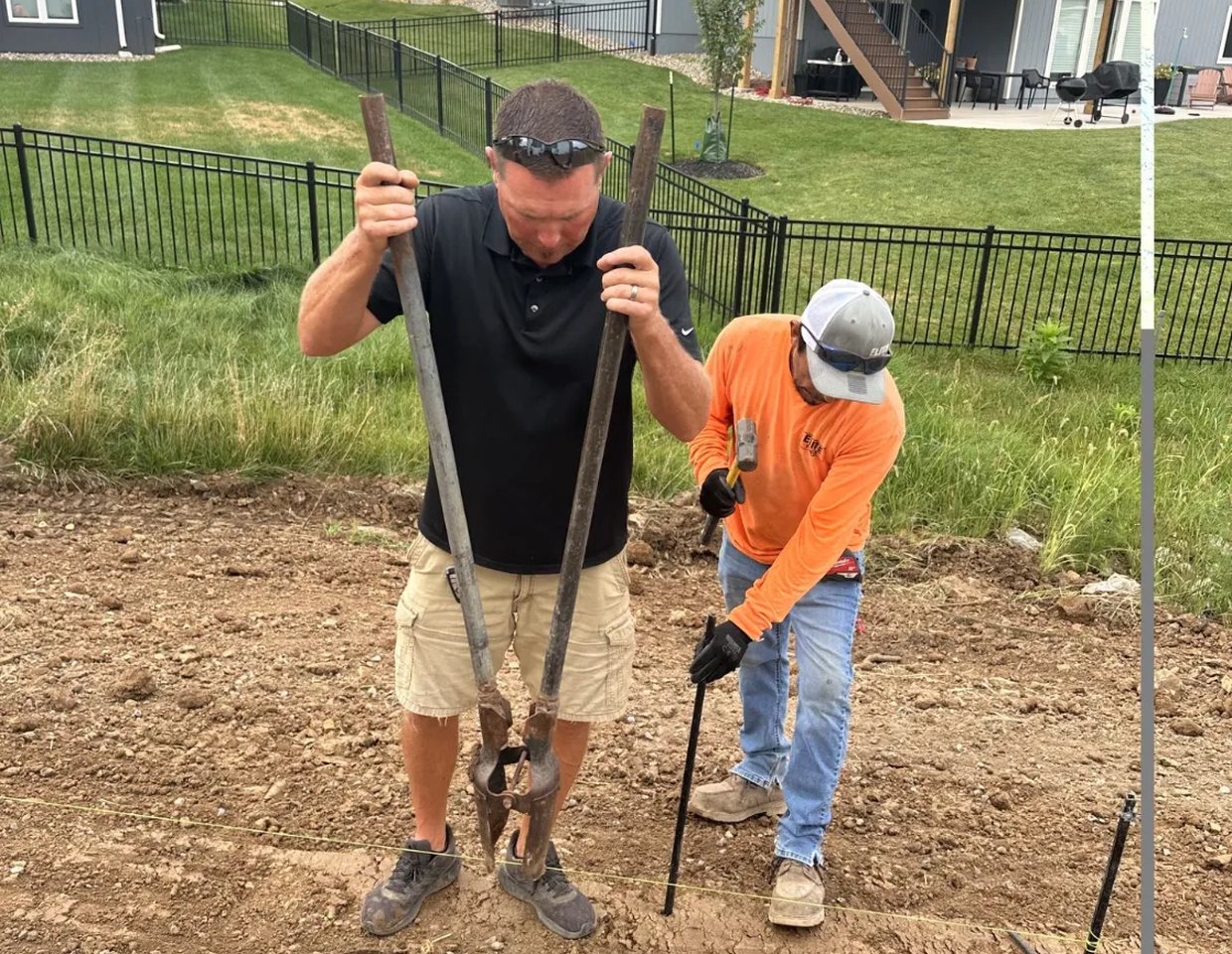 Kevin Lint helping an Elite Fence crew set fence posts on a residential job