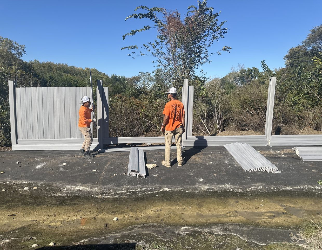 Elite Fence crew installing a gray vinyl privacy fence
